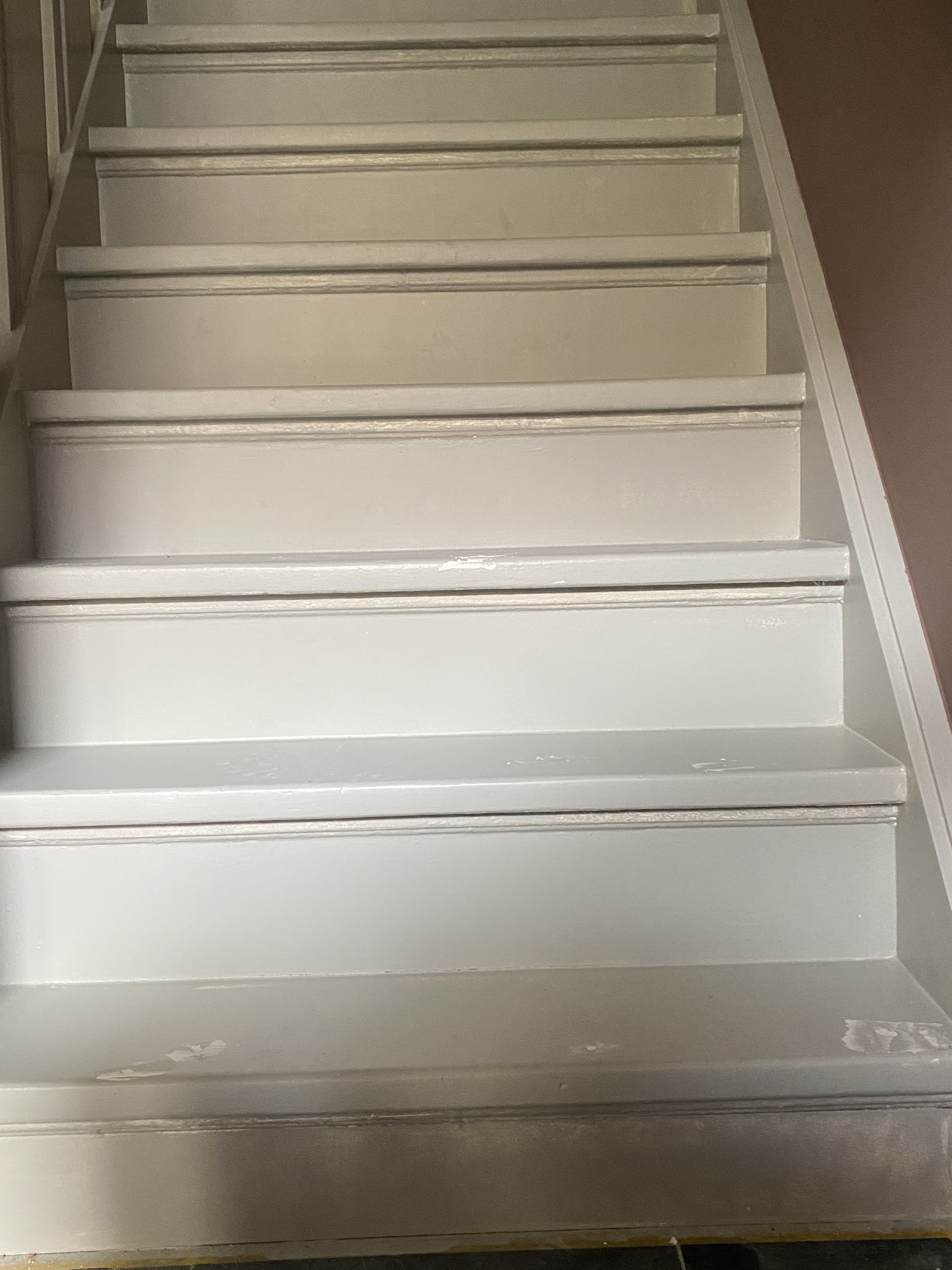 Een trap met wit geschilderde treden en stootborden